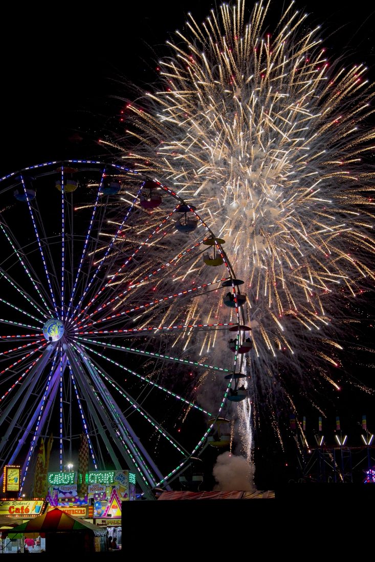 Golden fireworks erupting over a lit ferris wheel and carnival midway at night — Carolina Classic Fair, Winston-Salem NC