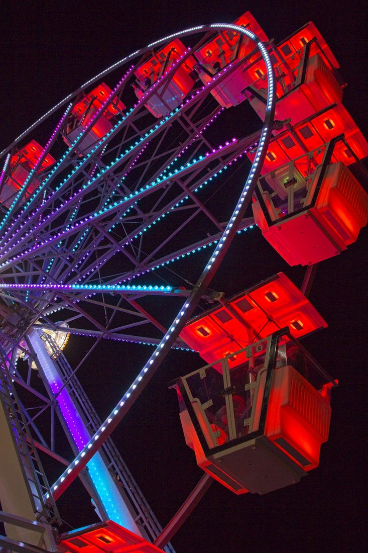 Illuminated ferris wheel cars glowing red and electric blue against the night — Carolina Classic Fair, Winston-Salem NC