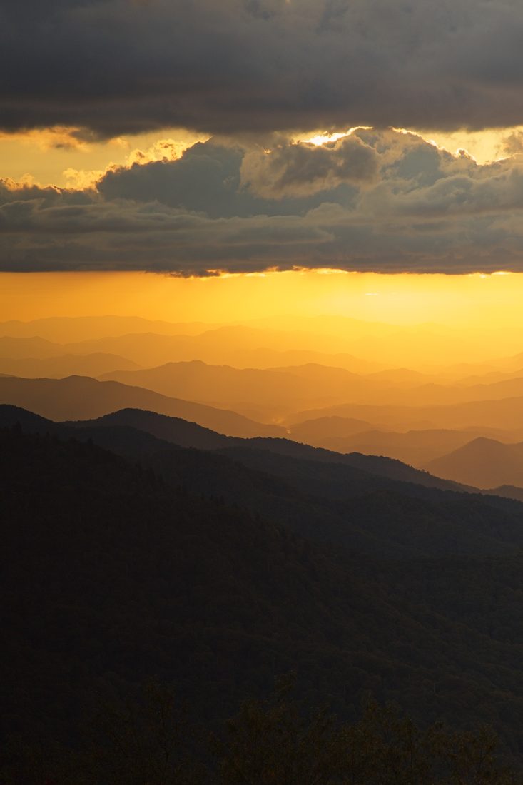 Vertical view of layered mountain ridges glowing in golden sunset light — Blue Ridge Parkway