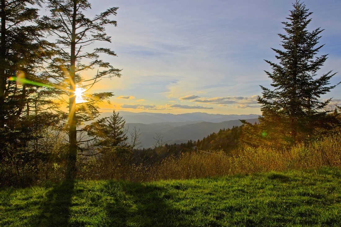 Warm sunset light raking across a wooded Appalachian ridge — Blue Ridge Parkway