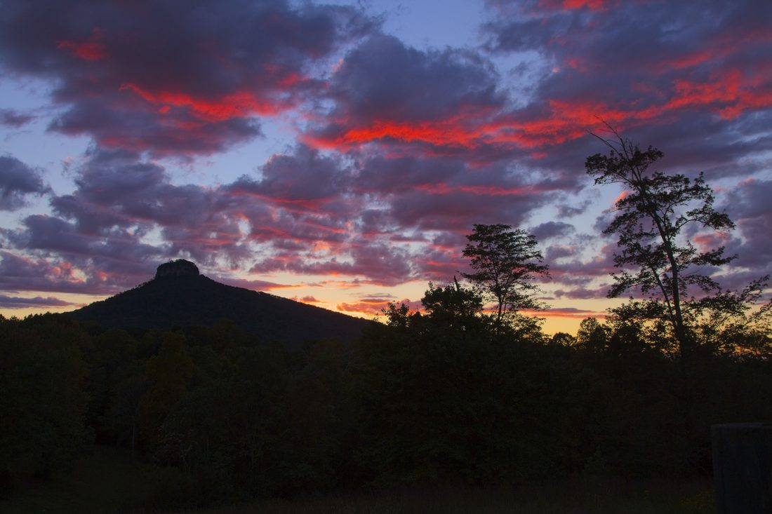 Fiery clouds over Pilot Mountain silhouette at sunset — Pilot Mountain, NC